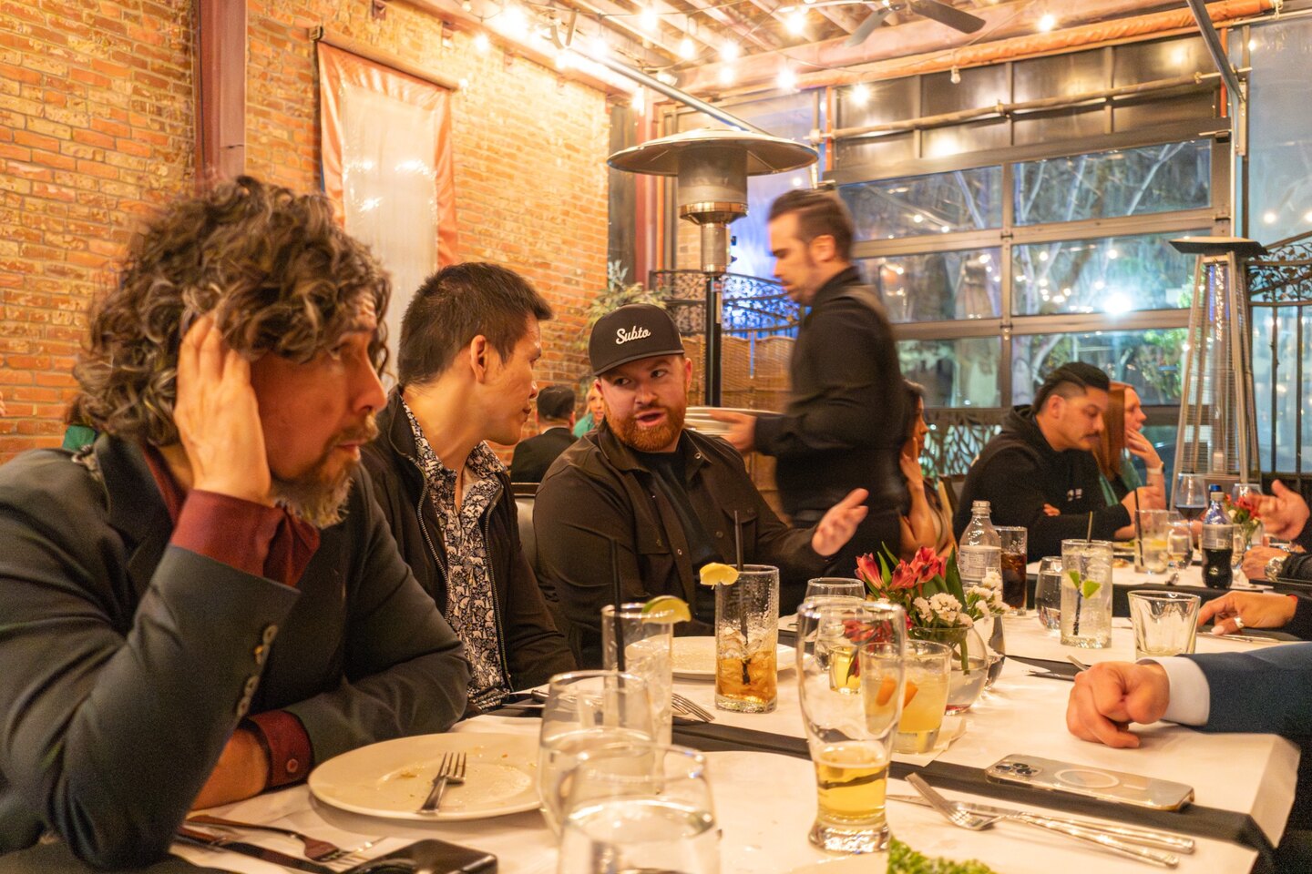 TELŌS attendees continuing their conversation around a restaurant table in March 2026
